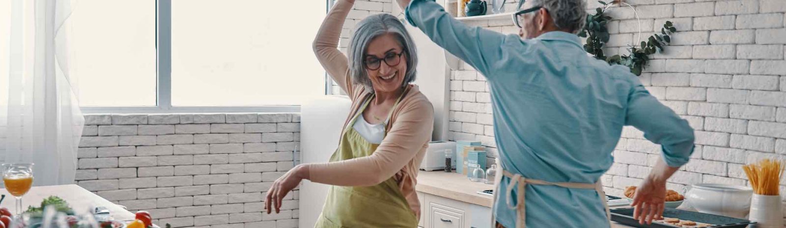 an elderly couple dancing in their kitchen