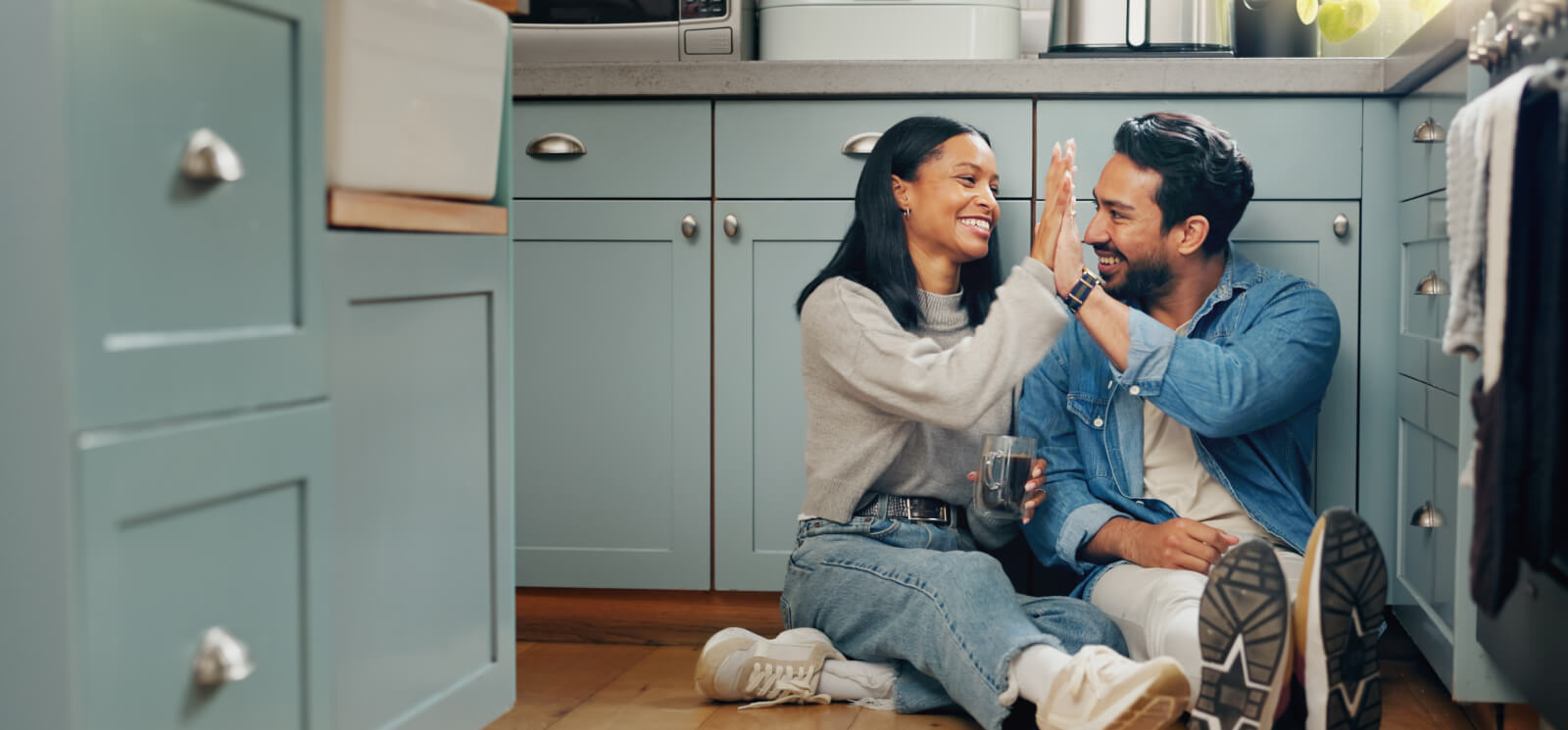 Couple high-fiving in kitchen