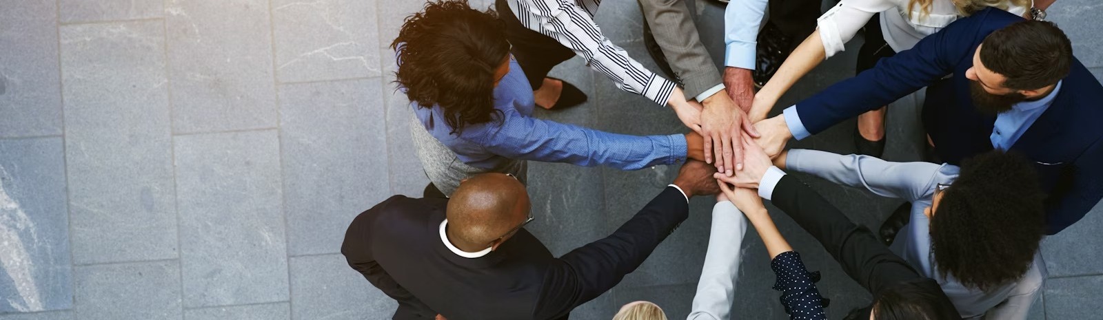 a group of business people with their hands in the center