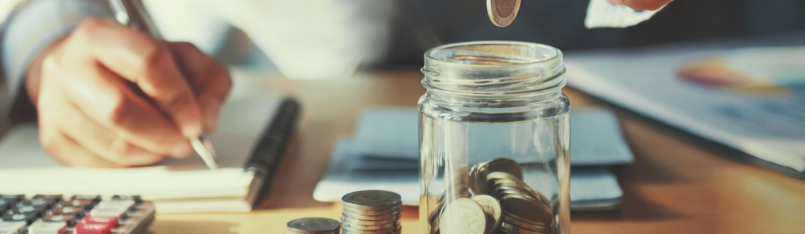 a person putting coins in a jar