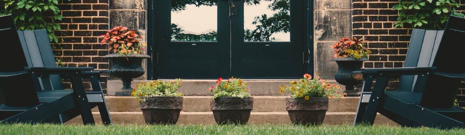 backyard door with potted plants and lawn chairs