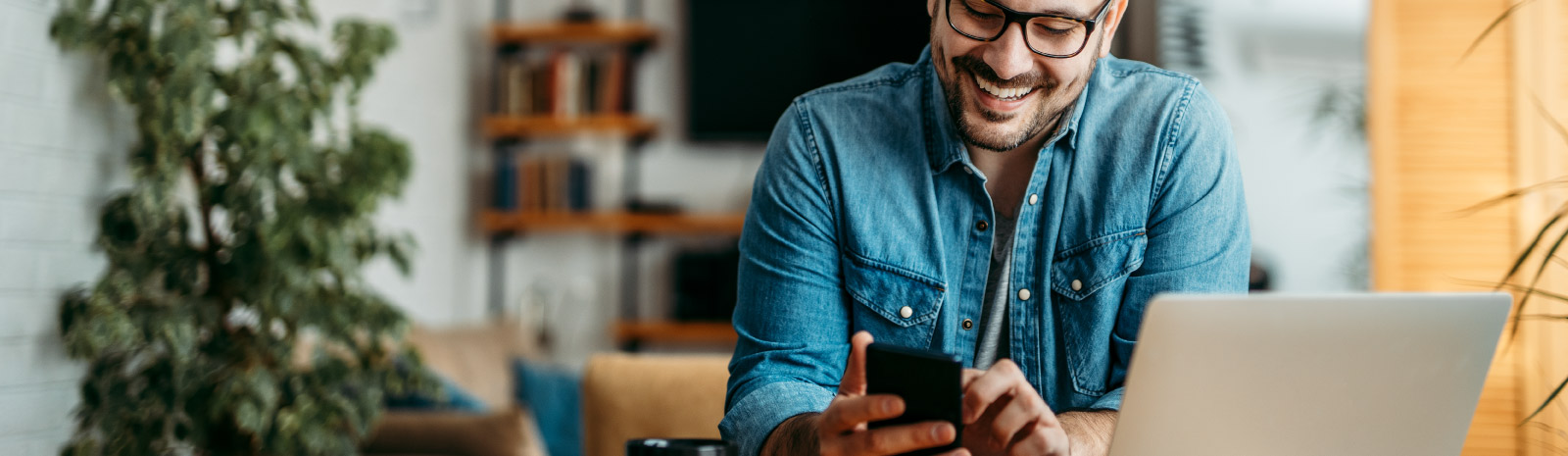 a man wearing glasses viewing his mobile device